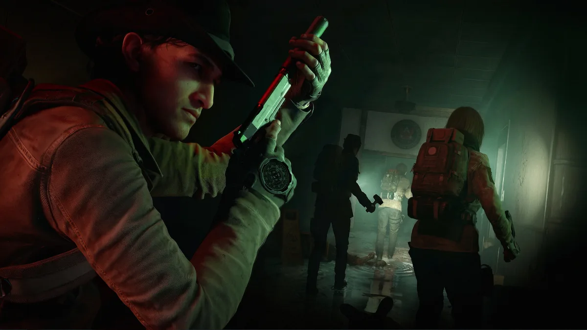 A responder checks a weapon while teammates move through a dim interior in official gameplay.